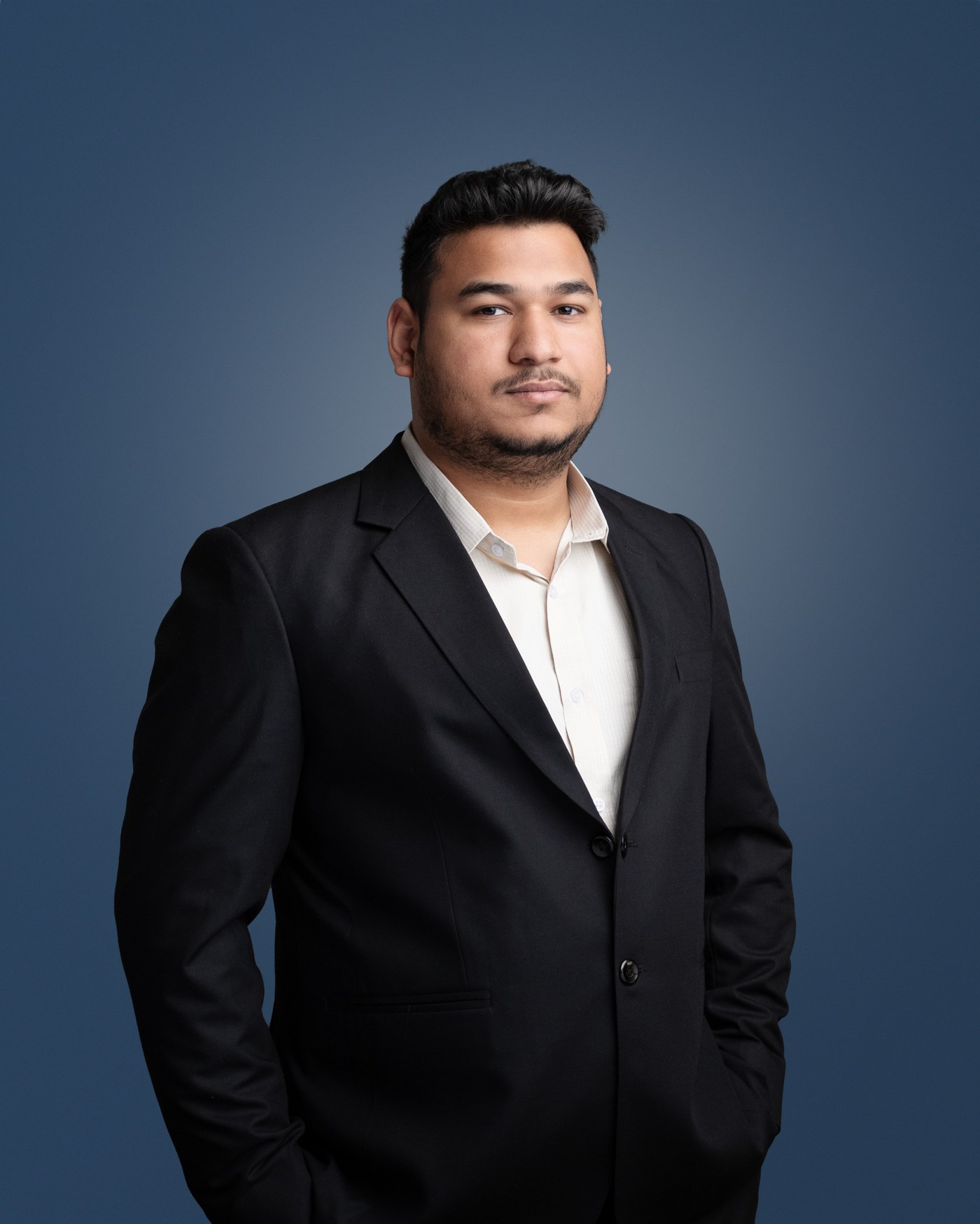 Portrait of Ronit Sriwastav, IT Sales Manager based in Sydney, photographed against a deep blue studio background.